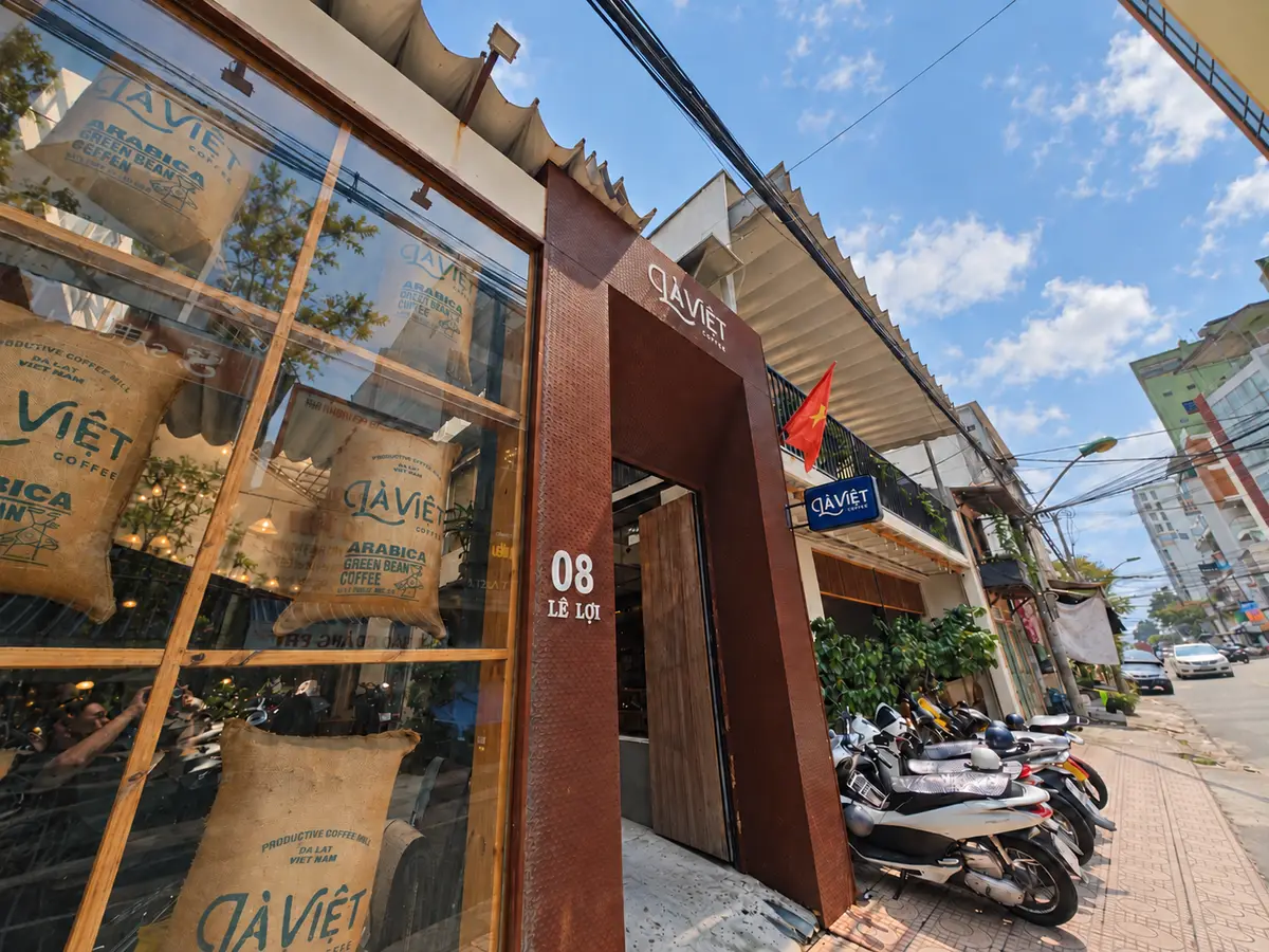 Brown shopfront with glass windows full of coffee bean sacks and the number eight on the wall
