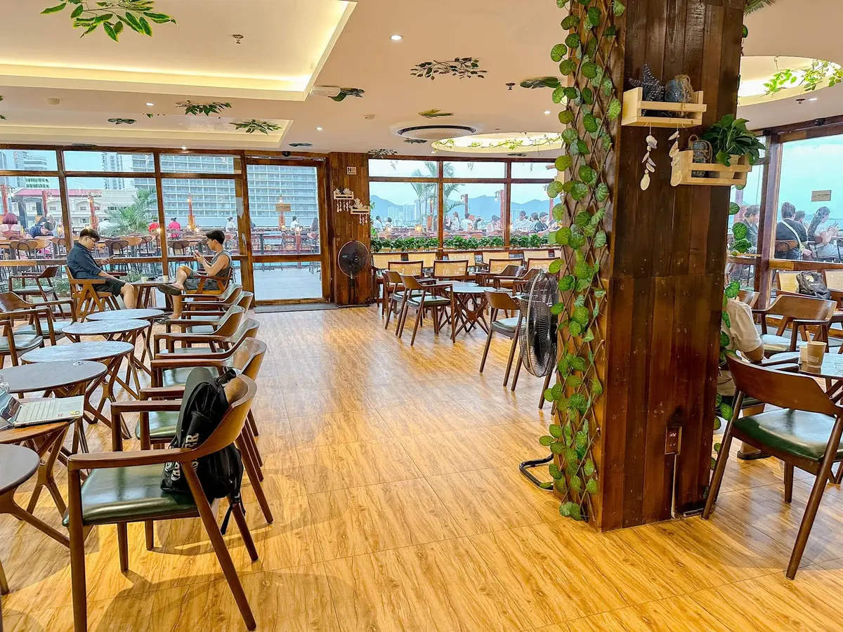 Indoor cafe room with wooden floor, tables and chairs and large windows