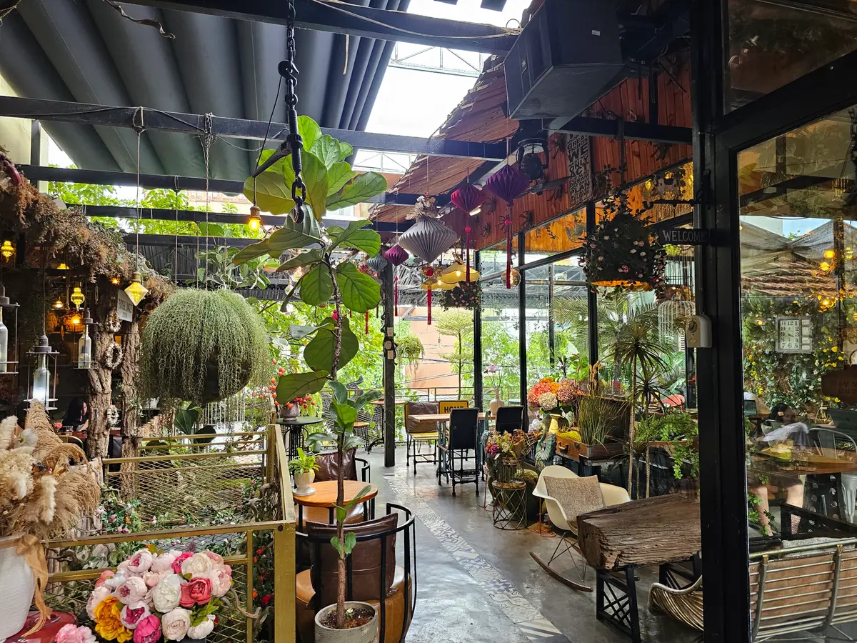 Covered garden cafe with hanging plants, wooden beams and flower pots