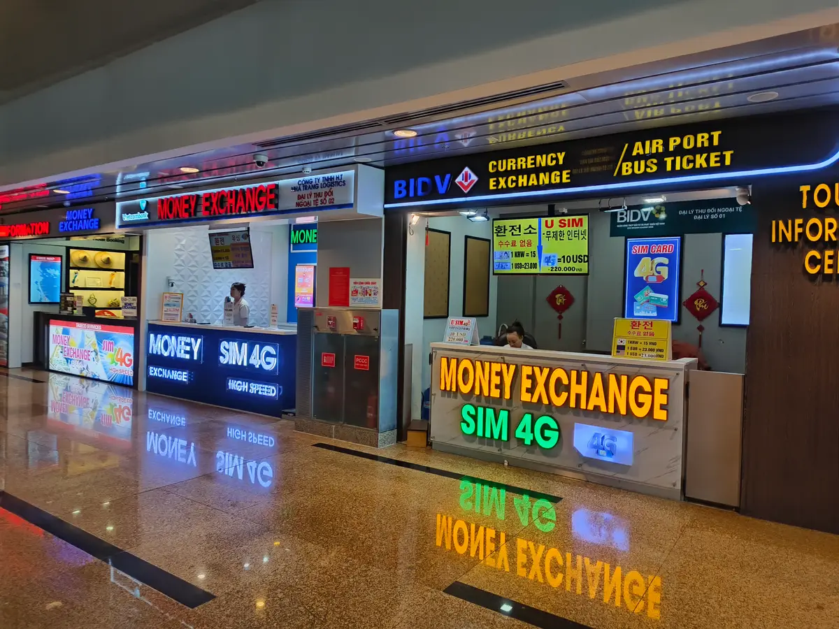 Currency exchange and SIM card counters in the Cam Ranh Airport terminal.