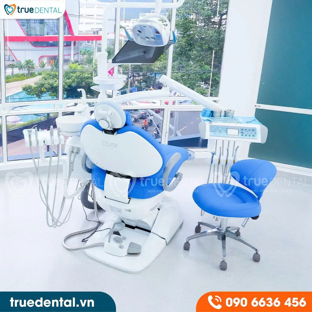 Dental treatment chair with a blue seat, overhead lamp and window light