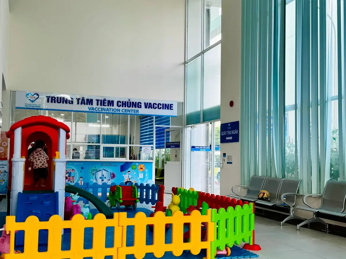 Vaccination centre counter in a bright lobby with a colourful play fence