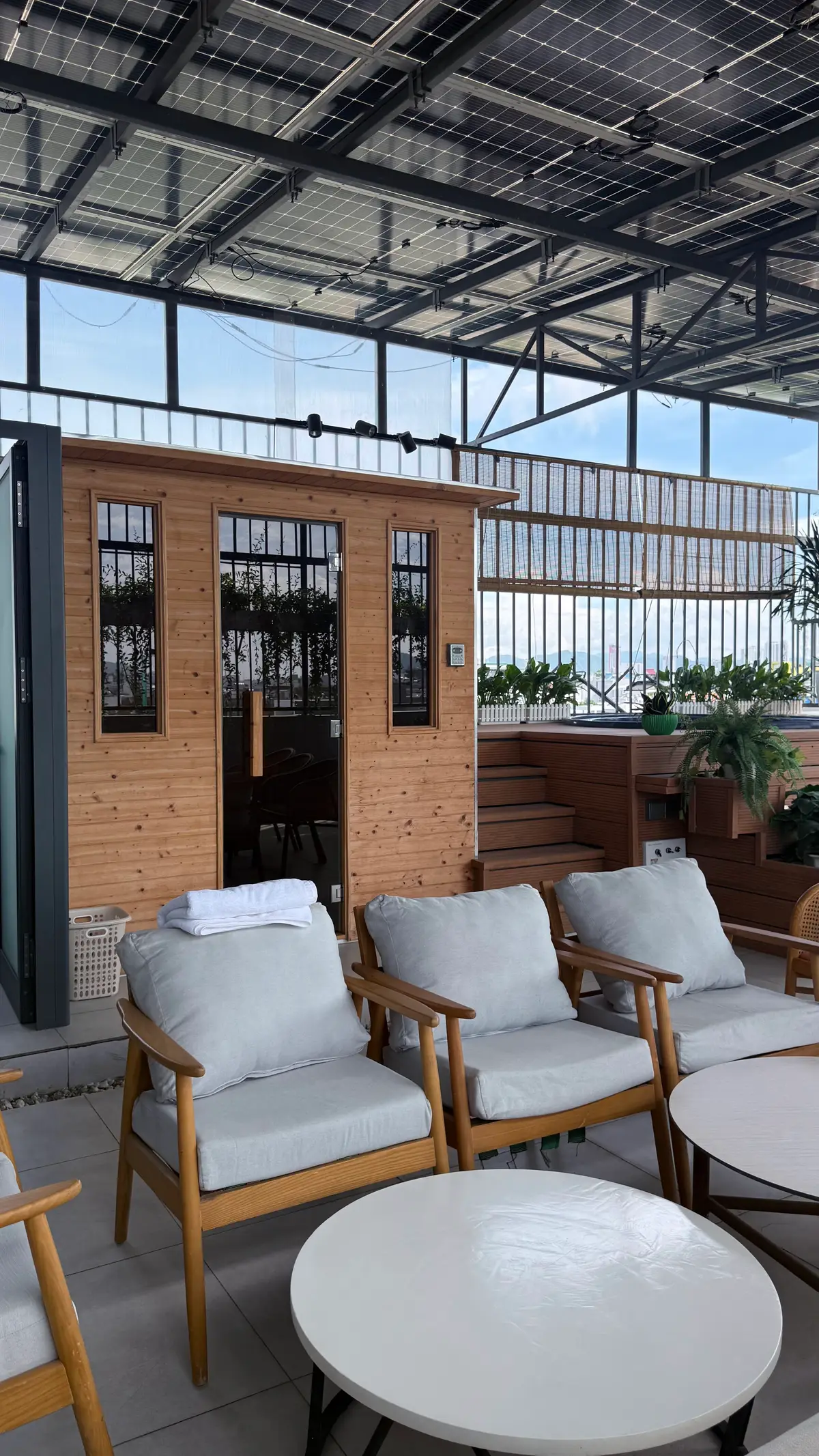 Wooden sauna cabin and grey loungers on a terrace