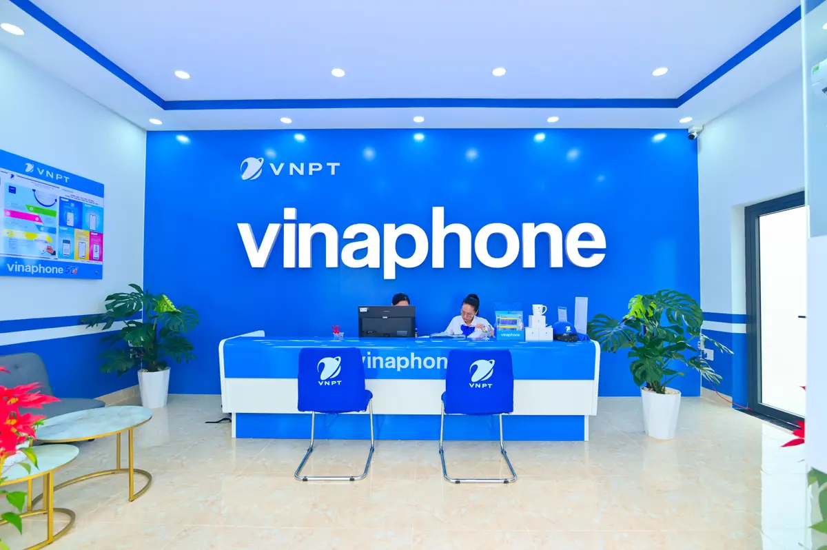 Blue VinaPhone service counter with staff behind it inside a VNPT point