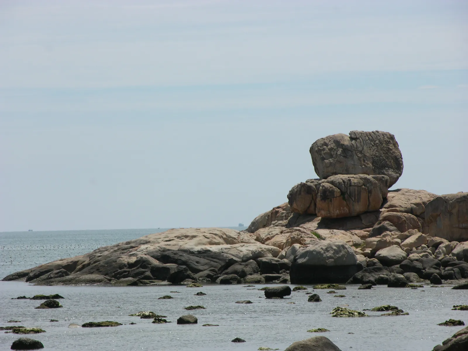 Granite boulders of the Hon Chong promontory seen across a beach