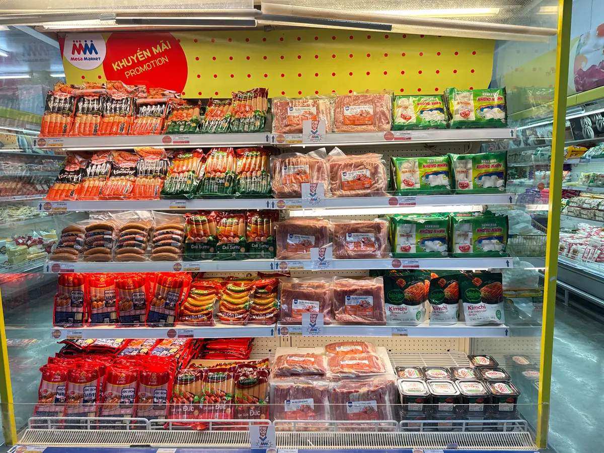 Chilled shelves stacked with sausages and packaged meats in red and green packs
