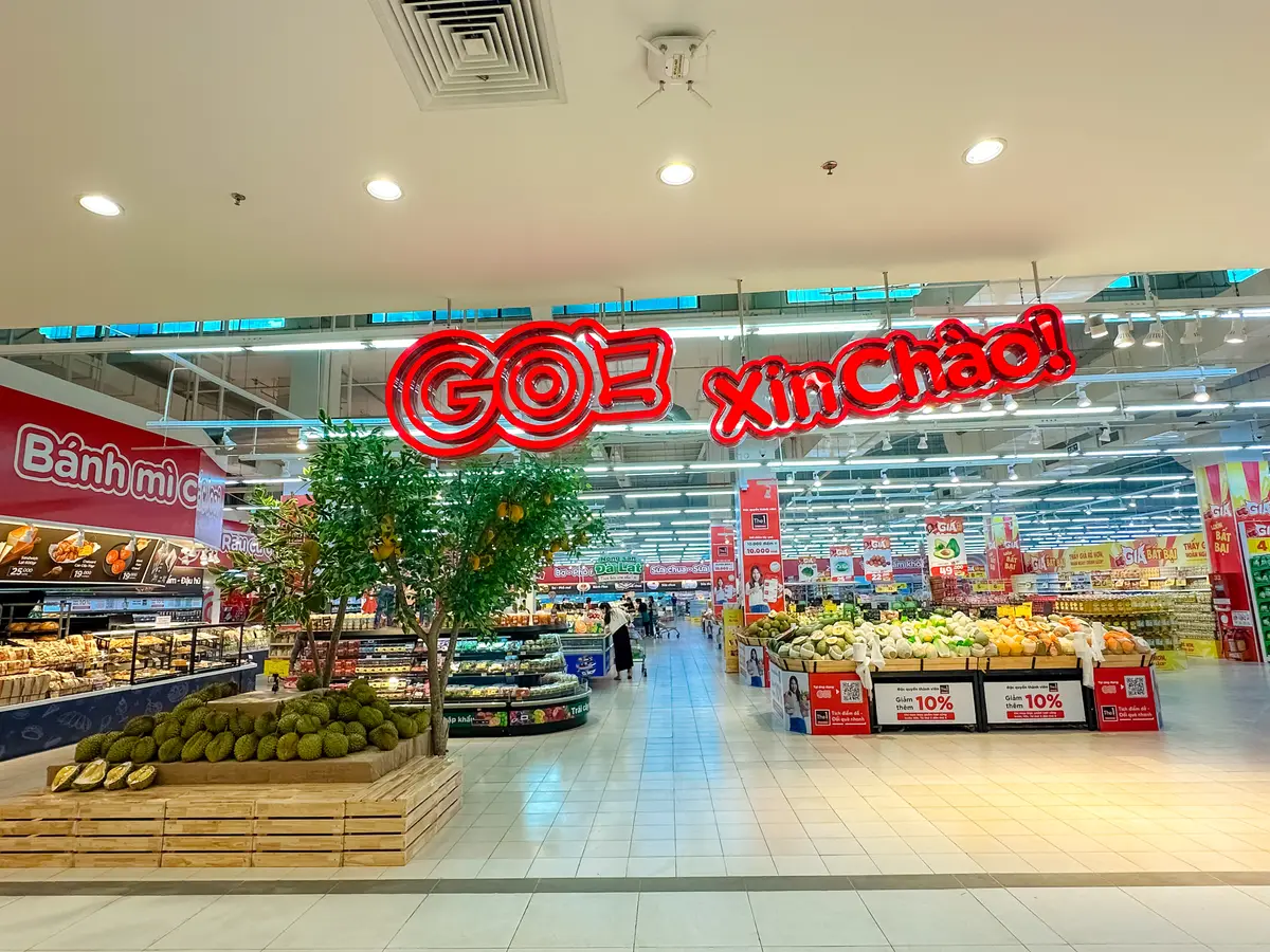 Hypermarket interior with a decorated tree and a red Xin Chao sign above the bakery