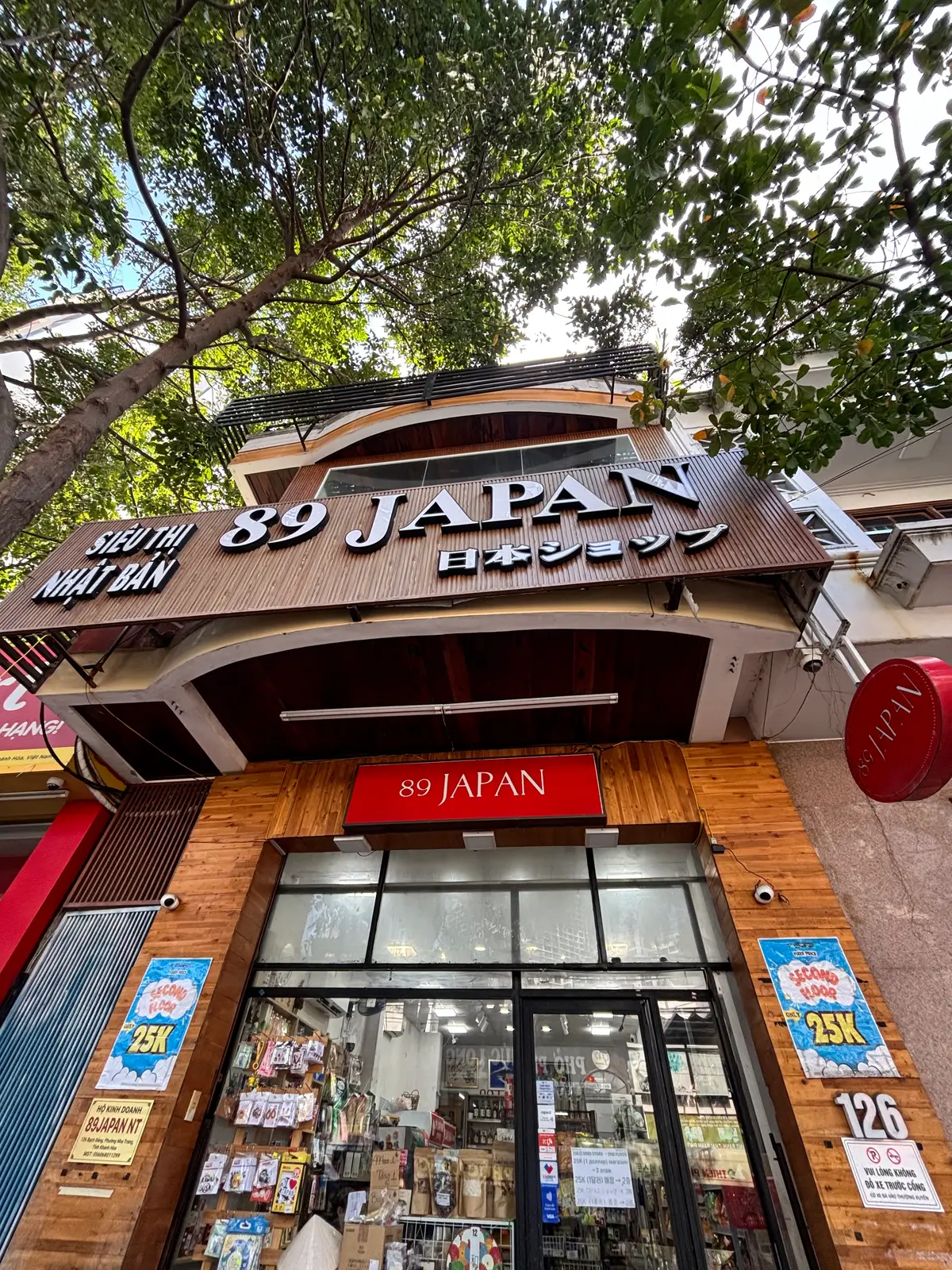 Wooden shop sign with Japanese characters above a glass shopfront