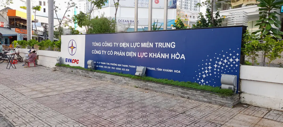 Blue street sign of the Khanh Hoa power company on a paved pavement outside the head office.