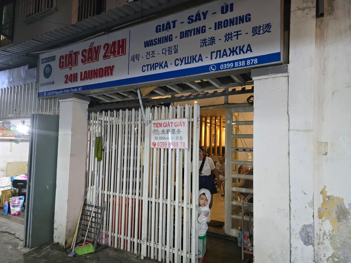 Entrance to a laundry shop with a multilingual sign above the door