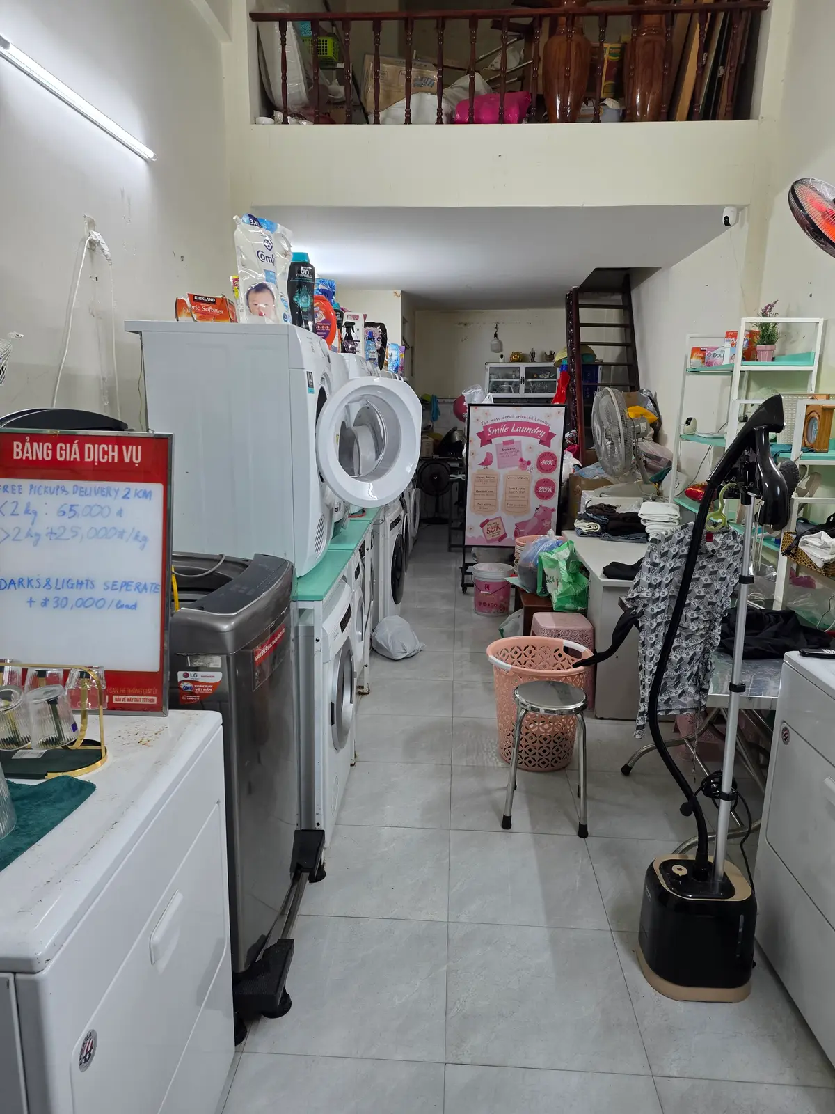 Small laundry shop interior with washing machines, a counter and shelves