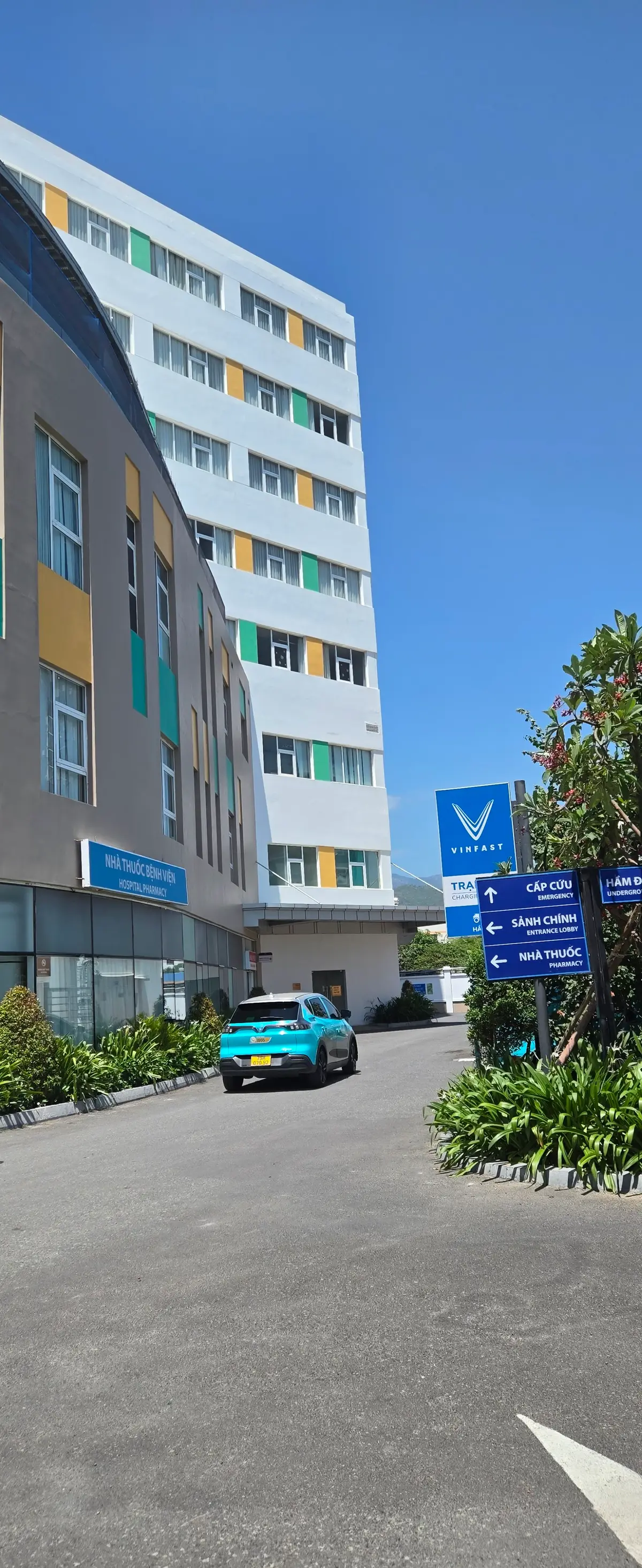 Vinmec Nha Trang building with a blue emergency direction sign pointing to emergency, outpatient and pharmacy