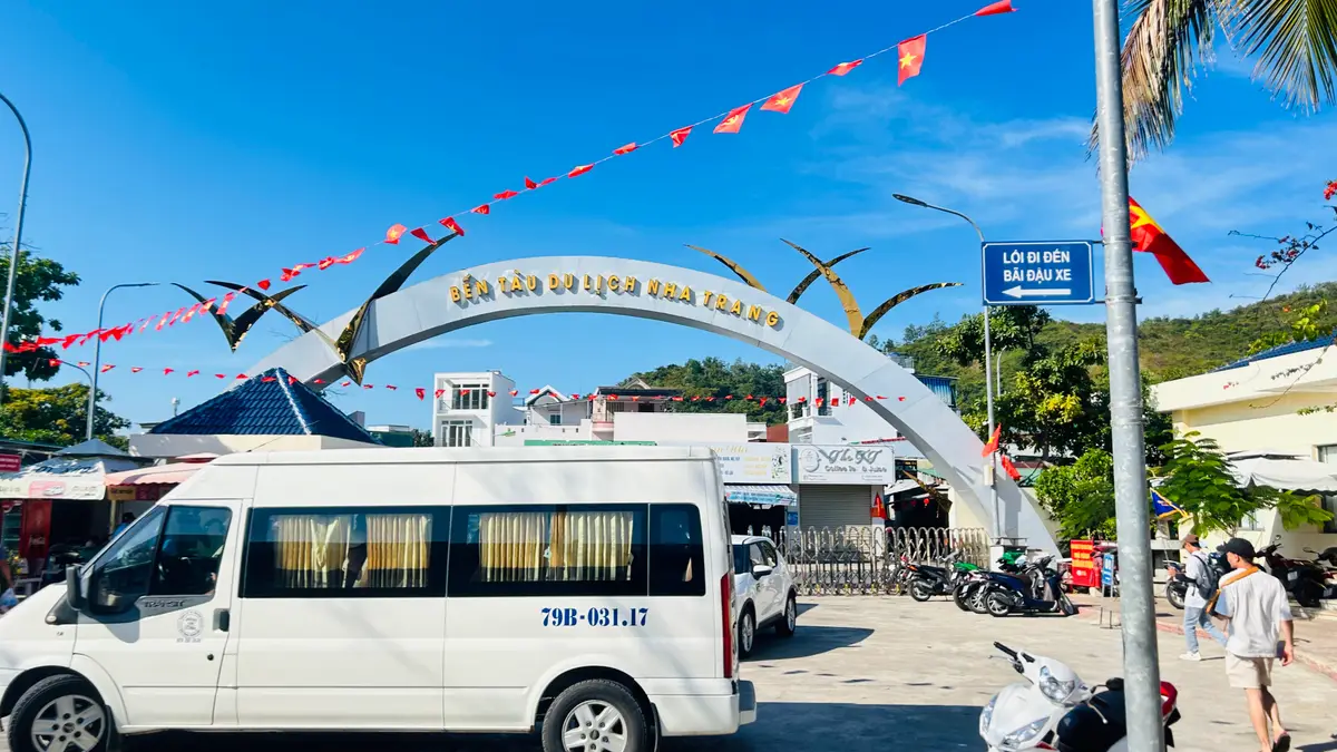 Curved welcome arch over the pier entrance with a white minibus parked in front