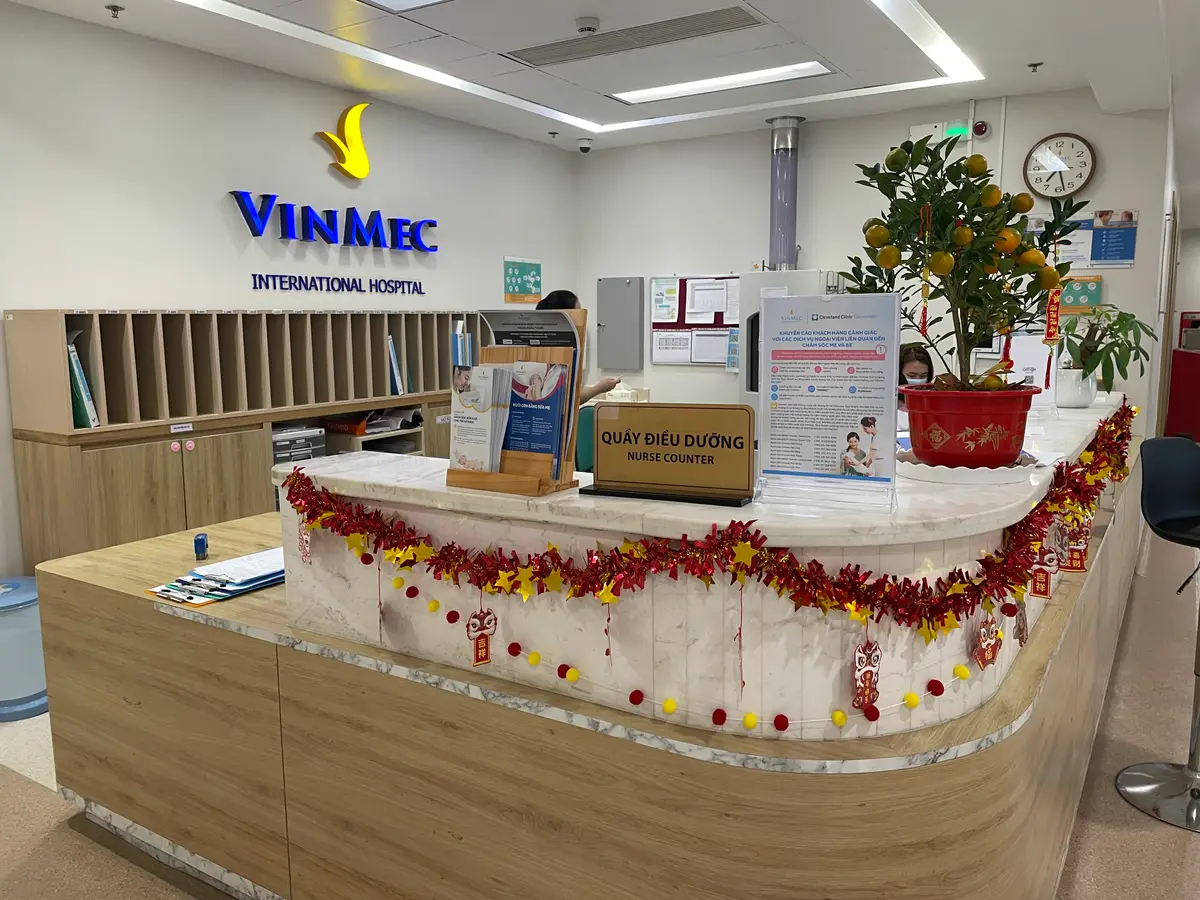 Reception counter decorated with flowers beneath a Vinmec sign