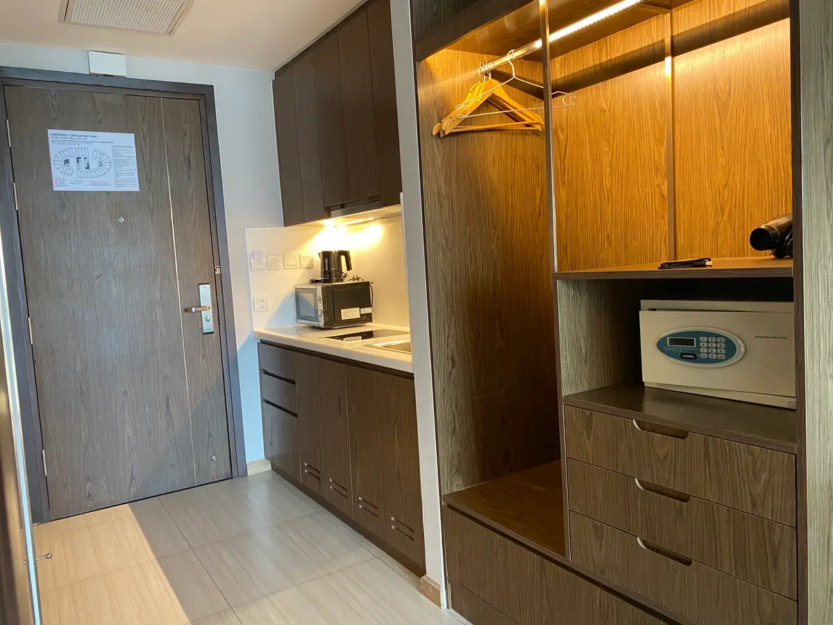 Apartment interior with a wooden wardrobe, a small safe and a kitchen counter