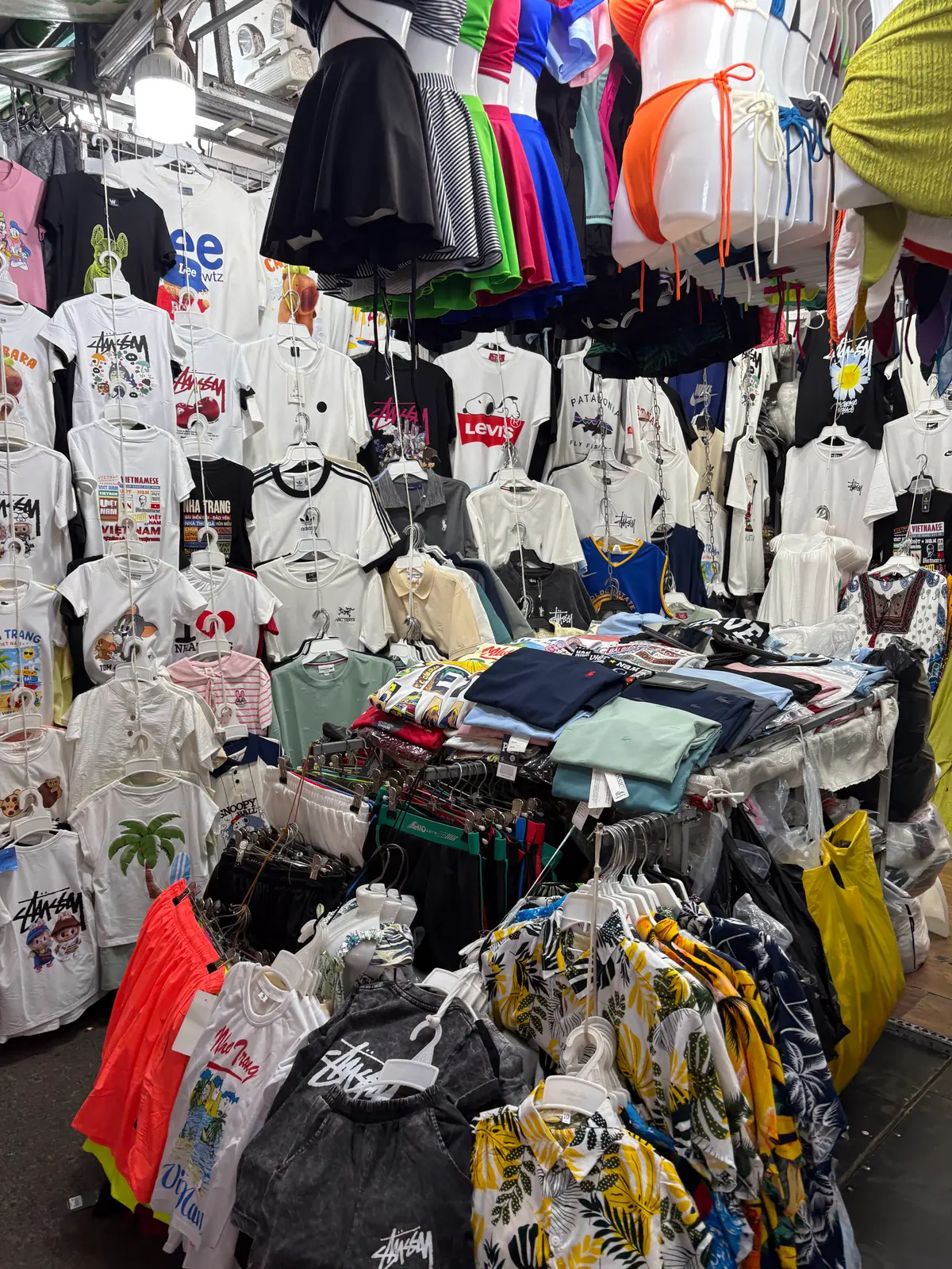 Racks of printed T-shirts hanging at a clothing stall