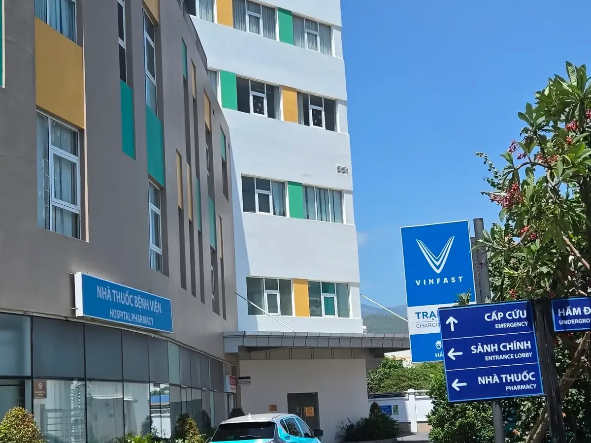 Hospital building with blue direction signs pointing to emergency and pharmacy