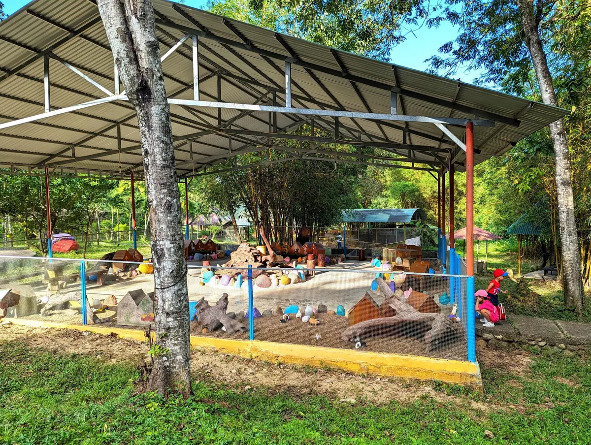 Roofed play area with colourful rock-shaped play features on a grass lawn