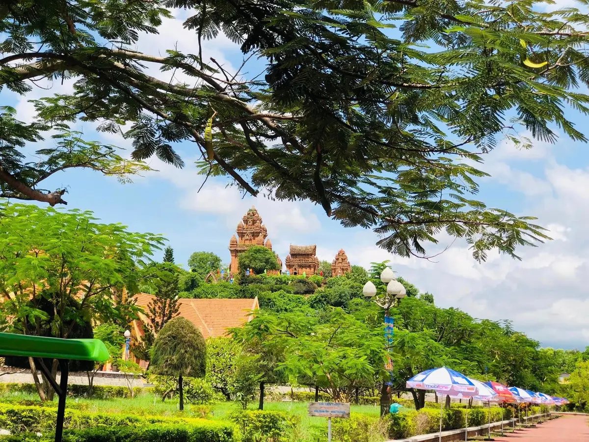 Hillside park with trees and a tiled roof, and the towers on the skyline