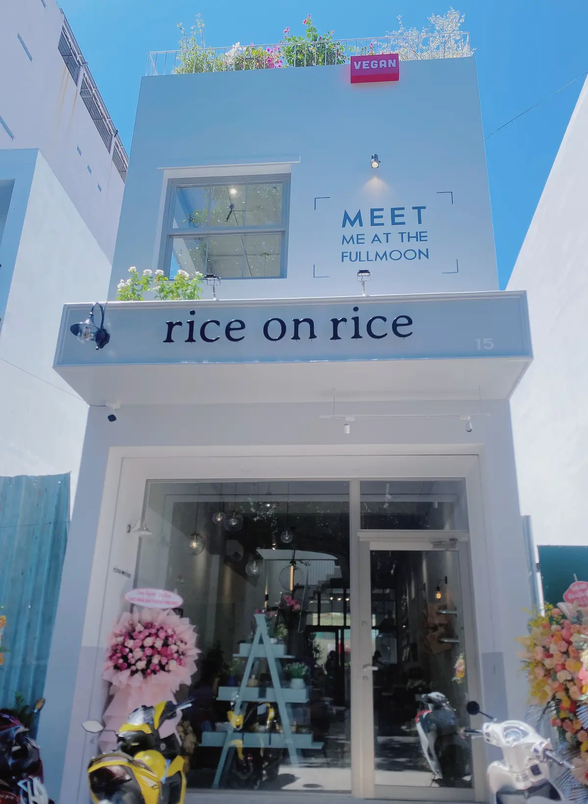 White cafe front with a lowercase rice on rice sign above glass doors