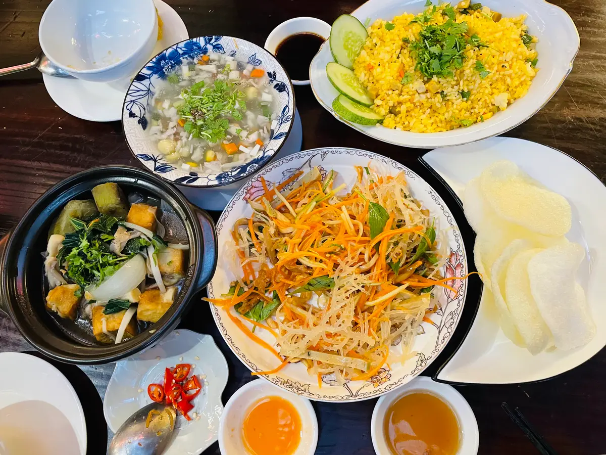 Table of vegan dishes with a bean sprout salad, soups and fried rice in small bowls