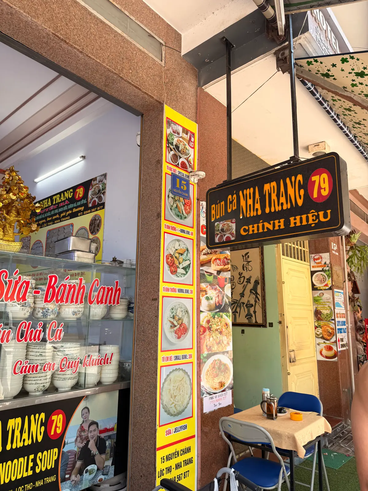 Shop counter with a black fish noodle soup sign and stacked bowls